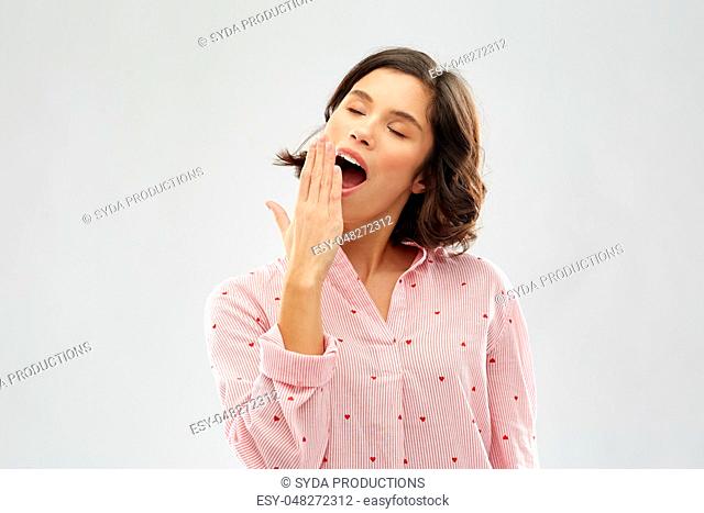 happy young sleepy woman in pajama yawning
