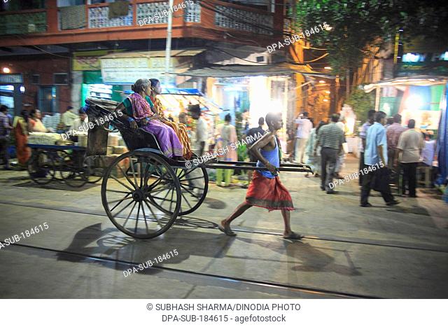 rickshaw puller transports passenger Durga Puja at Kolkatta India
