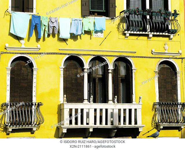 Washed clothes hanging on a yellow painted building. Cannaregio. Venice. Veneto. Italy