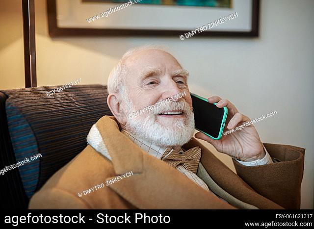 Important call. Senior businessman talking on the phone and looking serious
