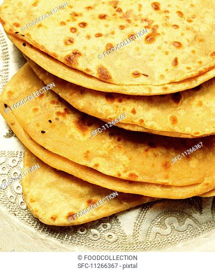 A stack of freshly baked naan bread
