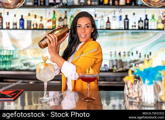 Female bartender preparing cocktails in bar