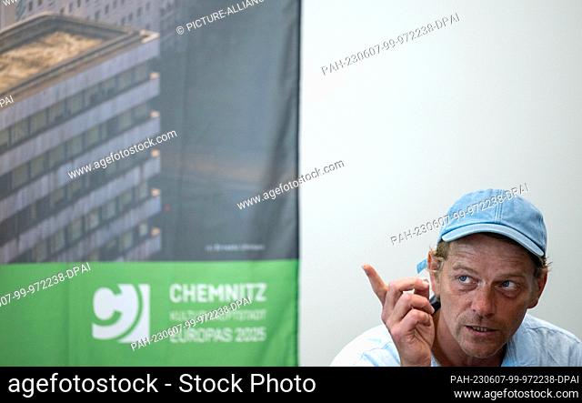 07 June 2023, Saxony, Chemnitz: Belgian artist Larsen Bervoets talks about his work on the roof of the building at the Stadthalle in Chemnitz