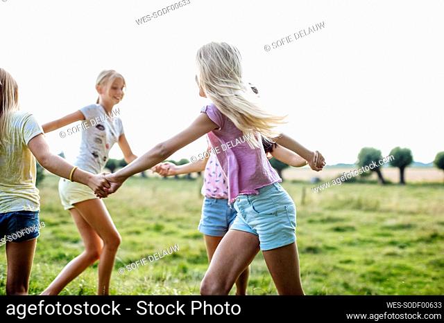 Happy girls dancing on a field together