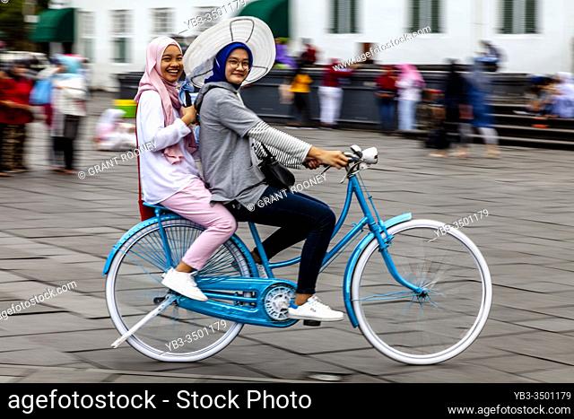 Young Indonesian Women Cycling In Taman Fatahillah Square, Jakarta, Indonesia