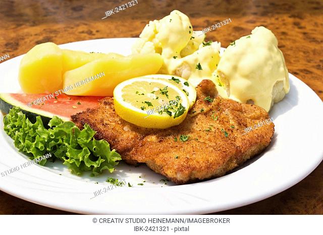 Breaded pork cutlet with boiled potatoes and cauliflower with sauce hollandaise