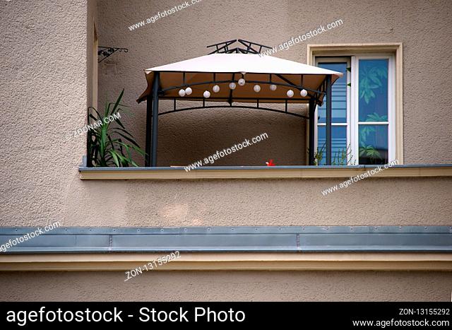 Der Balkon eines Mehrfamilienhauses mit einem Unterstand aus Zeltplane
