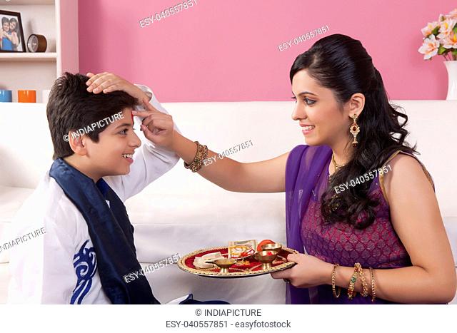 Sister applying tilak to her brother at Raksha Bandhan