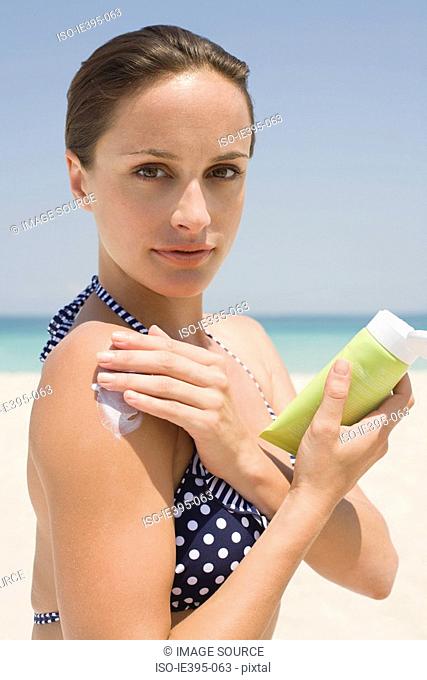 A woman applying suncream