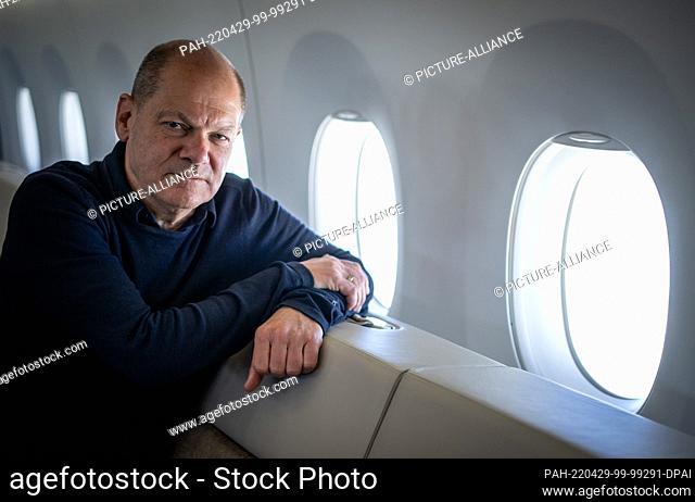 29 April 2022, Nordpol/Berlin: German Chancellor Olaf Scholz (SPD) looks into the photographer's camera in the Air Force Airbus A350 on the way back from Tokyo...