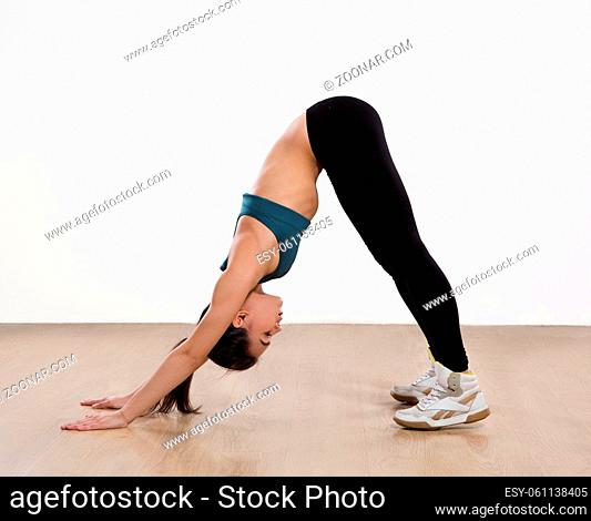 Young woman doing yoga bridge pose isolated on white background. Beautiful woman practicing yoga in studio or gym