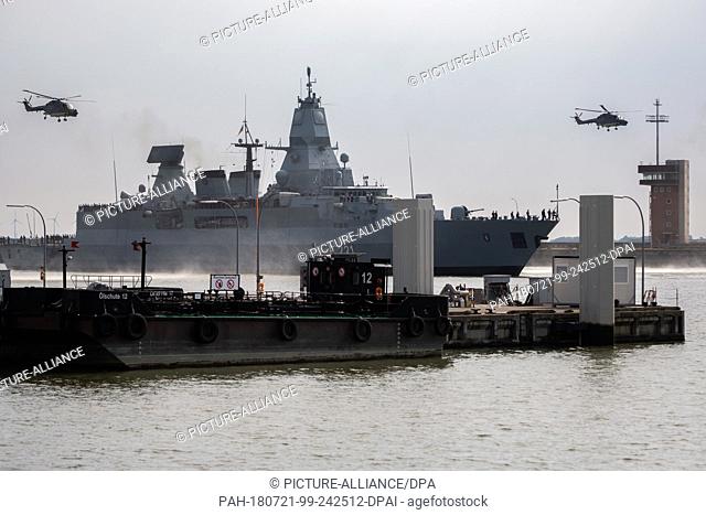 21 July 2018, Germany, Wilhelmshaven: The German navy ship 'Hessen' is accompanied by two helicopters as it returns to the harbour after completing training...