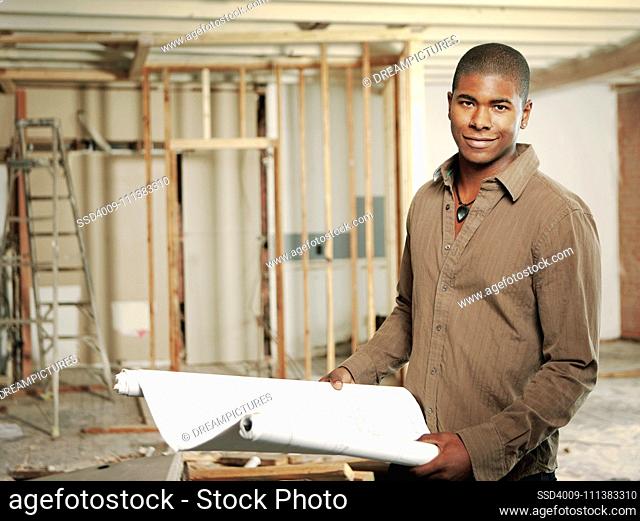 Architect holding blueprints in construction site