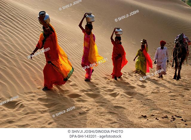 Girls and camel man in search of water ; Khuhri ; Jaisalmer ; Rajasthan ; India