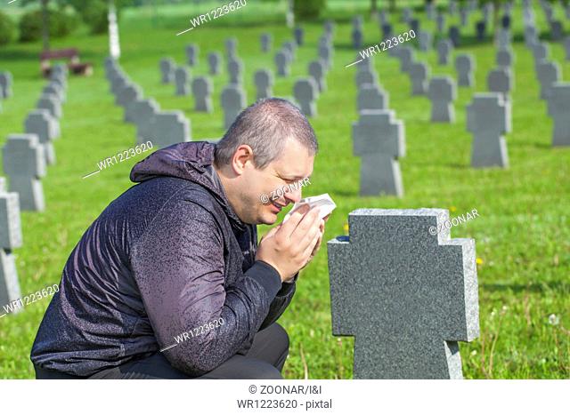 Man crying on the soldier's grave