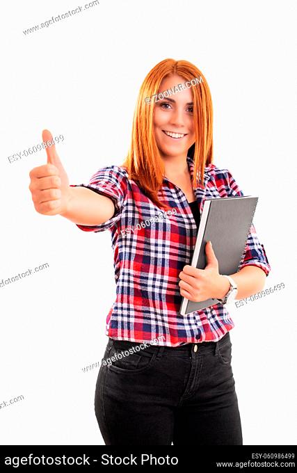 Beautiful smiling young woman holding a notebook and giving thumb up, isolated on white background. Successful student girl showing a positive gesture