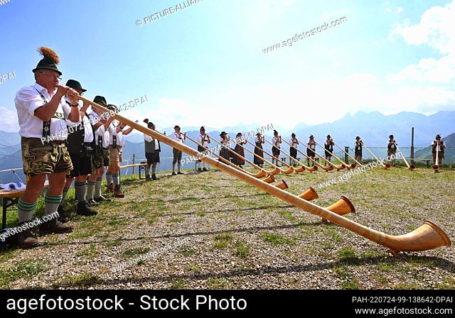 24 July 2022, Bavaria, Oberstdorf: Members of the alphorn group EUREGIO via salina make music at the 30th Berglar-Kirbe on the Fellhorn in front of the panorama...