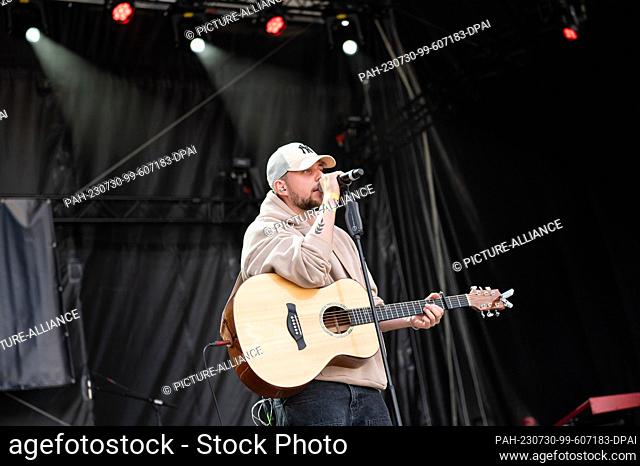 SYMBOL - 29 July 2023, Baden-Württemberg, Mannheim: Musician Luca Noel stands on stage with his guitar during a concert in the courtyard of honor of the baroque...