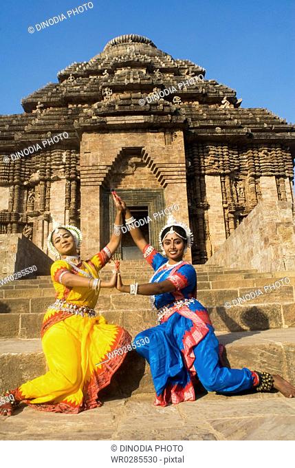 Odissi dancers strike pose re-enacts Indian myths such as Ramayana in front of world heritage Sun temple complex in Konarak , Orissa , India MR400