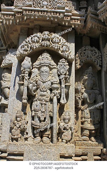 Close up of stone sculpture of lord Bramha under eves on shrine outer wall in the Chennakesava Temple, Hoysala Architecture at Somnathpur, Karnataka, India
