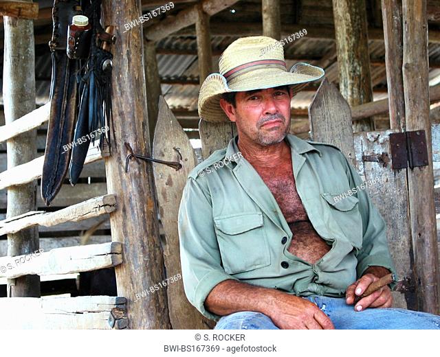 farmer with sun hat and cigar sitting at the stable, Cuba, Pinar del Rio