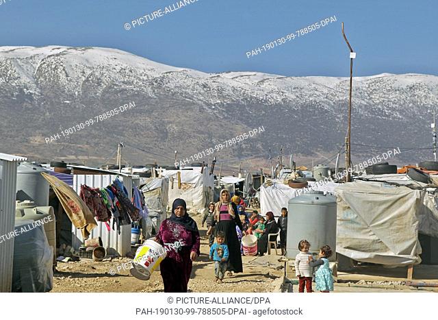 30 January 2019, Lebanon, Al Marj: Syrian refugees walk between the tents of Al Marj refugee camp. Lebanon, host of some 1