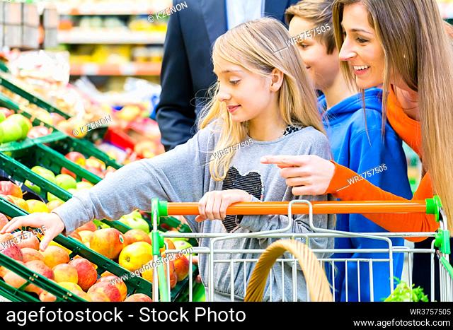 Family in supermarket selecting fruits while grocery shopping