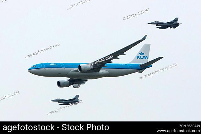 LEEUWARDEN, NETHERLANDS - JUNE 11 2016: Dutch KLM Boeing escorted by two F16 fighter jets of the Dutch air force on juni 11 , 2016 in Leeuwarden