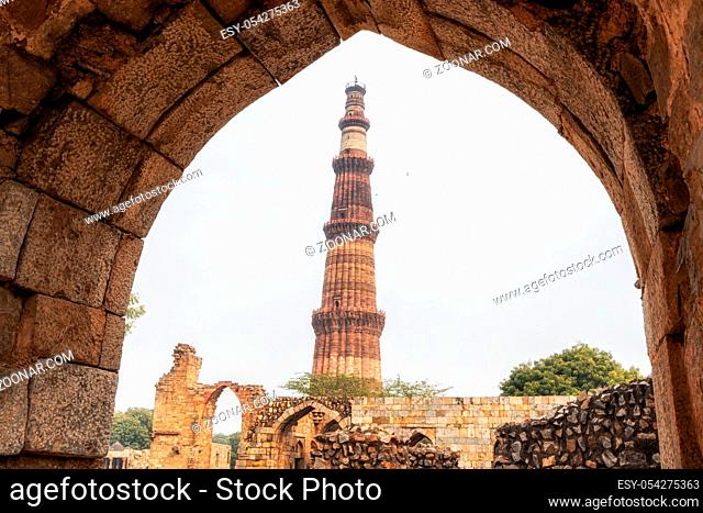 qutub minar in new delhi surrounded by various ruins viewed from below. New Delhi, India