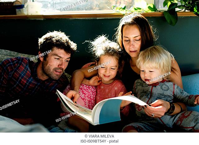 Parents reading to children in bed