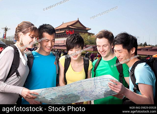 Five people looking at map with Tiananmen Square in background