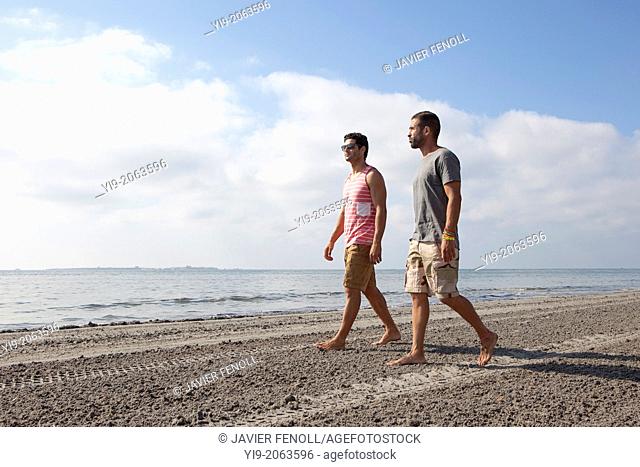 two men walking on the beach