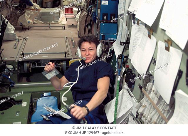 Astronaut Peggy A. Whitson, Expedition Five flight engineer, uses a communication system in the Zvezda Service Module on the International Space Station (ISS)