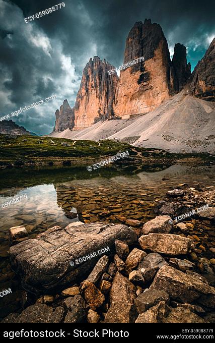 Three Peaks in the Dolomites reflecting in a lake, Italy during summer