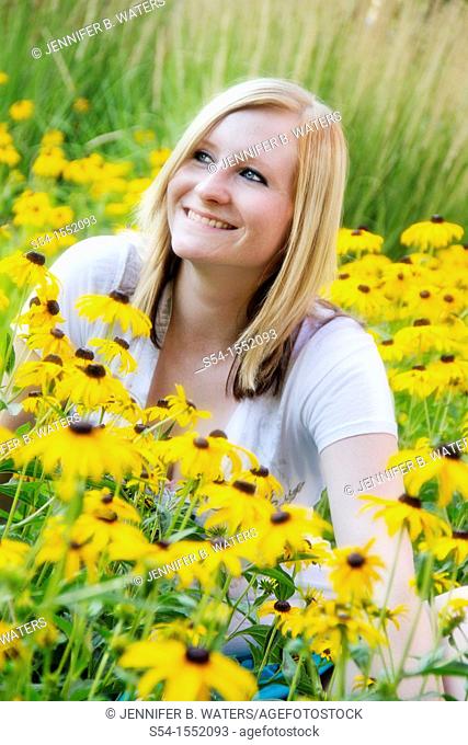 A happy young woman in a garden on Black-eyed Susan flowers, Lewiston, Idaho, USA