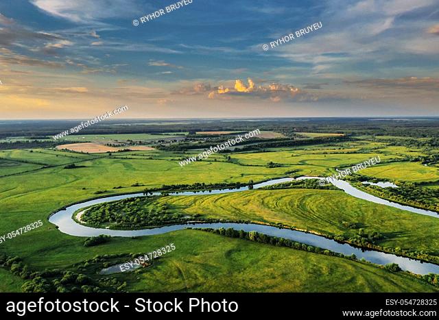 Aerial View Of Green Forest, Meadow And River Landscape In Sunny Evening. Top View Of European Nature From High Attitude In Summer Sunrise