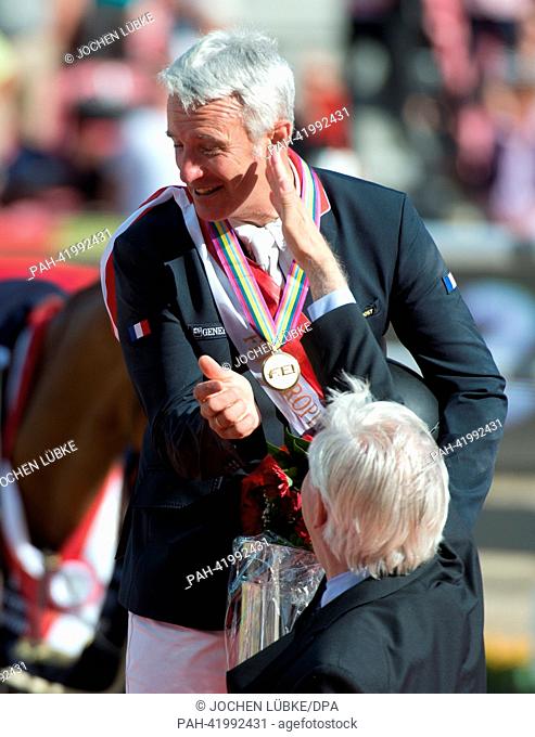 Winner French show jumper Roger Yves Bost shakes hands with former German show jumper Paul Schockemoehle during the presentation ceremony in the first round of...