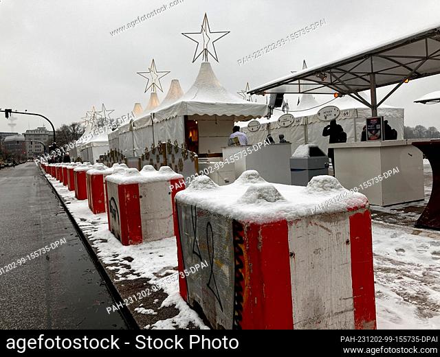 02 December 2023, Hamburg: Red and white concrete blocks are set up along a street in front of a Christmas market. Following the latest arrests for allegedly...