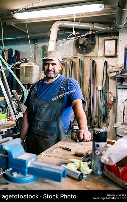 Portrait of a confident knife maker in his workshop