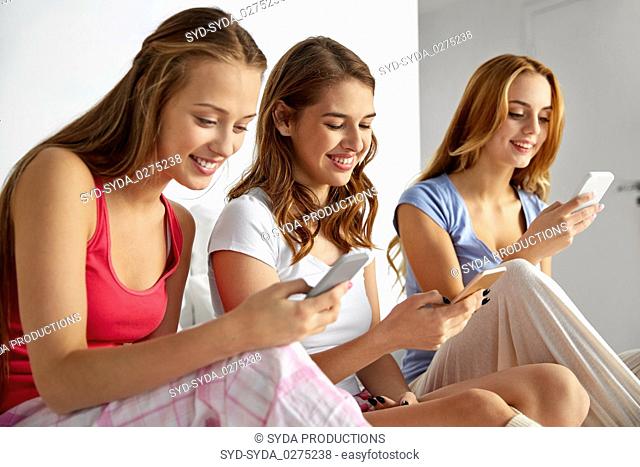 friends or teen girls with smartphones at home