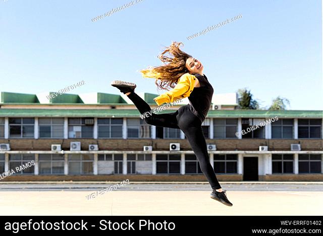 Happy teenage girl jumping outdoors