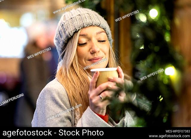 Smiling woman holding coffee cup at Christmas market