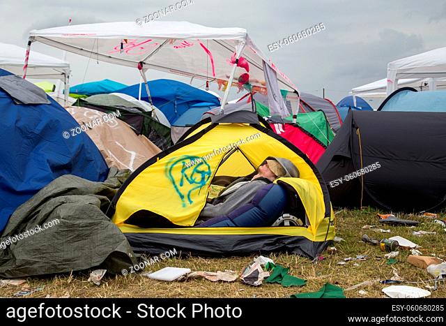Roskilde, Denmark - July 1, 2016: Young man sleeping in his tent on the camping area at Roskilde Festival 2016