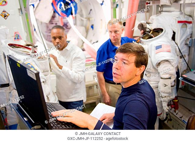 NASA astronauts Michael Barratt (foreground), Alvin Drew (left background) and Tim Kopra, all STS-133 mission specialists