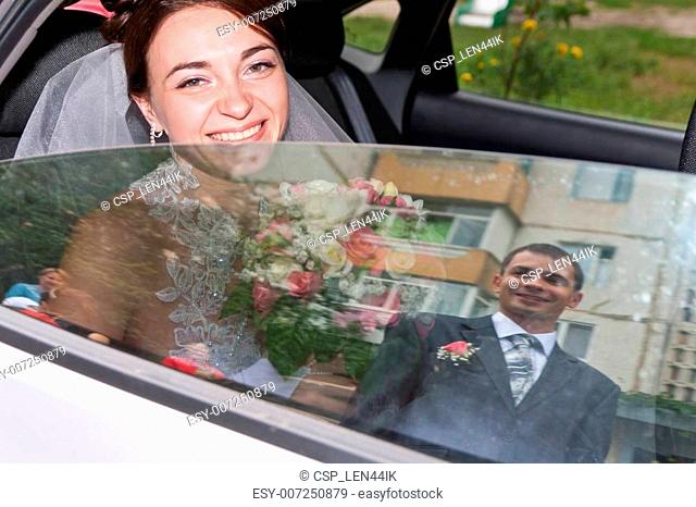 Beautiful bride looking out from car window