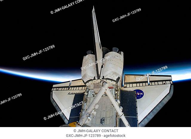 Intersecting the thin line of Earth's atmosphere, space shuttle Discovery is featured in this image photographed by an STS-131 crew member while Discovery...