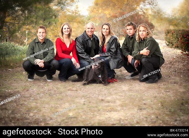 Happy, attractive family pose for a portrait outdoors