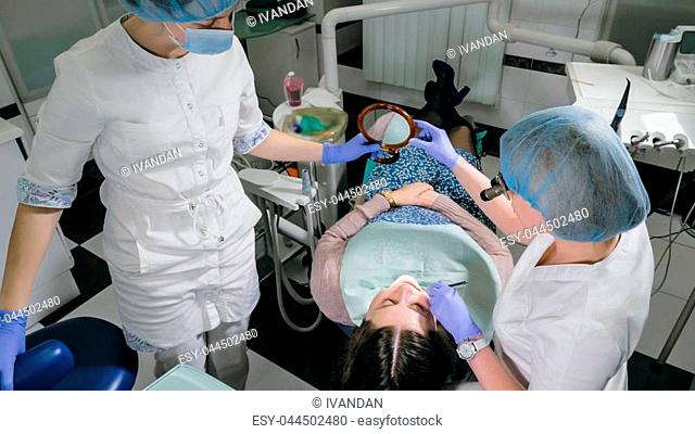 Woman at dentist clinic gets dental treatment to fill a cavity in a tooth. Dental restoration and composite material polymerization with UV light and laser