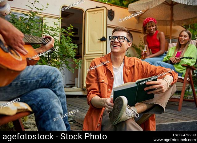 Group of young people chilling spending time at campsite. Millennial man and woman feeling happy and joyful having fun on holidays