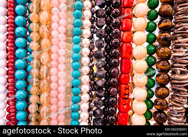 Wallpaper background of colorful necklace made of gemstones and colored beads showcased in a shop. Semi precious jewelery